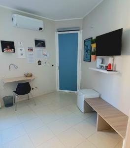 Cette chambre comprend un bureau, une table et une porte. dans l'établissement Scilla Guest House, à Scilla