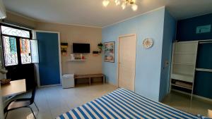 una camera da letto con pareti blu, un letto e una scrivania di Scilla Guest House a Scilla