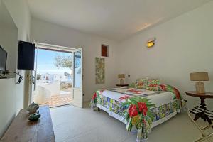a bedroom with a bed and a sliding glass door at Dependance La Caletta in Panarea