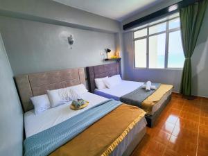 um quarto com 2 camas e uma janela em Glory Beach Resort 7+2 PAX Seaview Suite em Porto Dickson