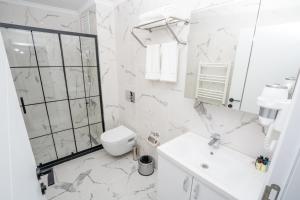 イスタンブールにあるGuest suiteの白いバスルーム(トイレ、シンク付)