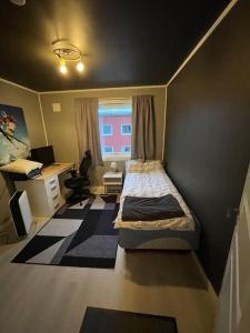 Habitación pequeña con cama y escritorio. en Narvik sentrum en Narvik