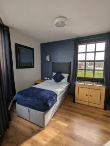um quarto com uma cama grande e uma janela em Cornmill Hotel em Hull
