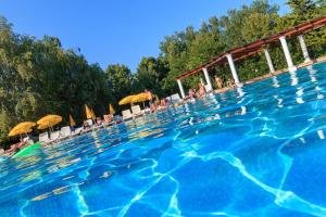 a large swimming pool with people and umbrellas at Hotel 2D Resort and Spa in Neptun