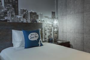 高雄的住宿－西悠巢旅-高雄車站館，一张带蓝色枕头的床,上面有标志