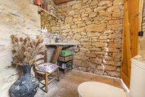 BiscarriにあるCal Sastreの石造りのバスルーム(トイレの隣に花瓶付)