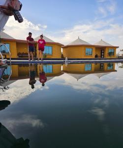 ジャイサルメールにあるLuxury The Sunrise Resort with swimming pool Jaisalmerの二人の男が水のプールに立っている