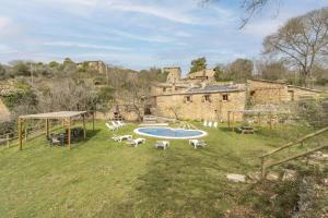 a yard with a pool and chairs and a building at Cal Sastre in Biscarri