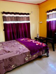 1 dormitorio con cama morada y cortinas moradas en Shri Krupa Homestay, en Diveagar