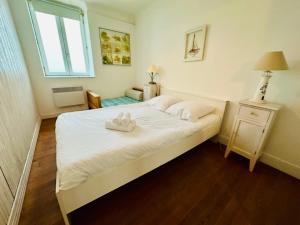 ein Schlafzimmer mit einem Bett mit zwei weißen Schuhen darauf in der Unterkunft Les Fleurons in Ambleteuse