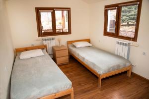 two beds in a room with two windows at EcoLodge in Wildlife Refuge in Urtsʼadzor