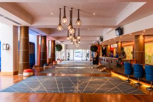 una hall con sedie blu in un edificio di Explorers Hotel Marne-la-Vallée a Magny-le-Hongre