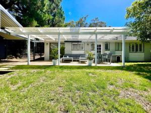 a white pergola on a house with a yard at Henderson House in Wentworth Falls