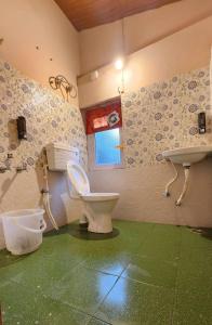 uma casa de banho com um WC e um lavatório em Wood House 1 em Ooty