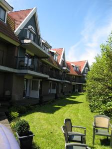 De Rijper Eilanden في دي رايب: صف من مباني الشقق مع كراسي في ساحة