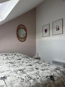 a bedroom with a bed and a mirror on the wall at duplex refait à neuf in Boulogne-sur-Mer