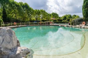 a large pool with blue water in a yard at Club del Sole Viareggio Family Collection in Torre del Lago Puccini