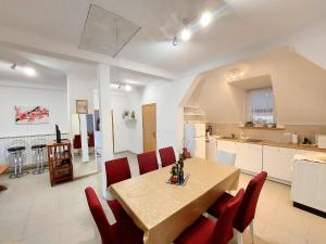 a kitchen and dining room with a table and red chairs at Apartman Jezerane in Jezerane