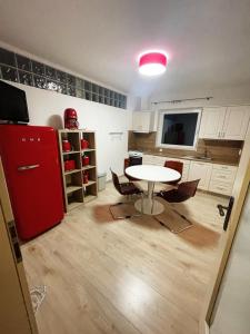 Il comprend une cuisine équipée d'une table et d'un réfrigérateur rouge. dans l'établissement Apartmán U VINAŘSTVÍ v RD novostavba v Suchohrdly u Znojma, à Suchohrdly