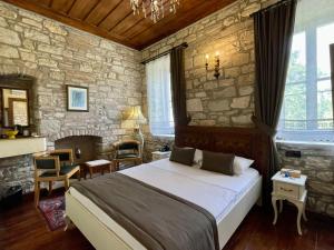 a bedroom with a large bed and a stone wall at Urla Taş Konak Otel in İzmir