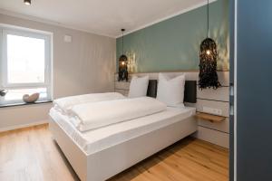a white bedroom with a large white bed and a window at Apartments by Altes Zollamt in Husum