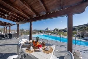 un patio con mesa, sillas y piscina en Villa Soave, en Citta' Sant'Angelo