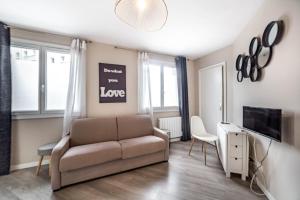 a living room with a couch and a tv at Appartement Passion - moderne et lumineux AIL in Lyon