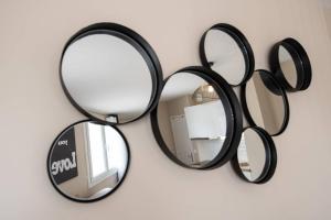 a group of mirrors hanging on a wall at Appartement Passion - moderne et lumineux AIL in Lyon