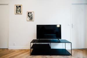 a living room with a glass table in front of a tv at All in Lyon | T2 design & climatisé – Centre in Lyon +22 photos