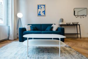 a living room with a blue couch and a table at All in Lyon | T2 design & climatisé – Centre in Lyon