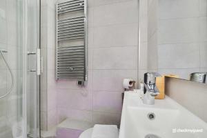 a bathroom with a shower and a sink and a toilet at Cosy Studio with Jacuzzi in Lively Pigalle in Paris