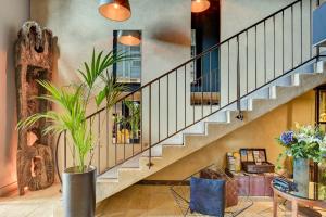 a living room with stairs and a table with a plant at Hotel Bastide & SPA - Villa de Lourmarin in Lourmarin