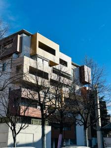 un edificio alto y blanco con árboles delante en Appartamento a Rivoli, en Rivoli