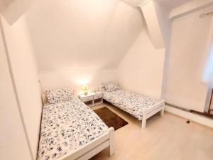 two beds in a small room with a window at Apartman Jezerane in Jezerane