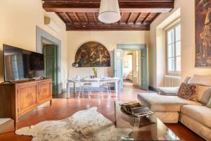 sala de estar con mesa y sofá en Ginny’s house- Borgo la croce luxury apartment, en Florencia