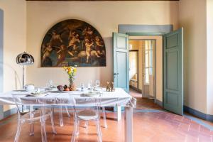 un comedor con una mesa y una pintura en la pared en Ginny’s house- Borgo la croce luxury apartment, en Florencia