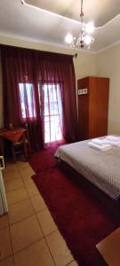 A bed or beds in a room at Erodios Guesthouse