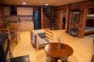 a living room with a table and a kitchen with a refrigerator at Ranger Campus Eco Lodge in Urtsʼadzor