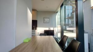 una habitación con una larga mesa de madera y sillas en Sky Stars Essential Home, en Auckland