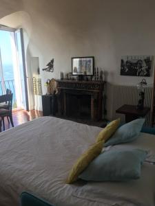 1 dormitorio con cama con almohadas y chimenea en Dans village médiéval piétonnier, Suite exécutive vue mer exceptionnelle, en Roquebrune-Cap-Martin