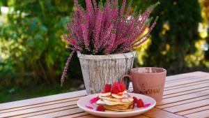 um prato de panquecas com morangos e uma chávena de café em Między Wierchami em Ponice