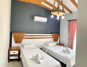 a room with two beds and a blue wall at Likya Akik 2+1 Villa, Özel Havuzlu in Fethiye