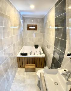 a bathroom with a bath tub and a sink at Likya Akik 2+1 Villa, Özel Havuzlu in Fethiye