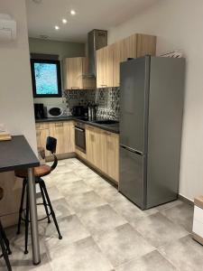 a kitchen with a stainless steel refrigerator and wooden cabinets at Résidence Alba in Bonifacio