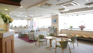 a waiting room with tables and chairs in a hospital at Hotel Kajigaya Plaza in Kawasaki