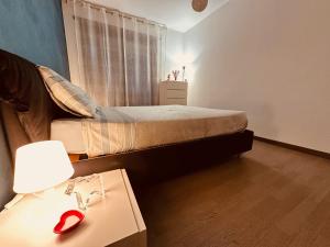 1 dormitorio con 1 cama y 1 mesa con lámpara en Appartamento a Rivoli, en Rivoli