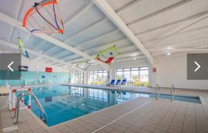a large swimming pool with kites flying above it at 49 Bayside Cove Pevensey Bay Holiday Park in Pevensey