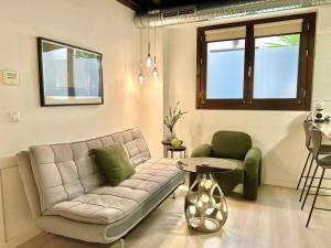 uma sala de estar com um sofá e uma mesa em Apartamentos Real Suites Realejo em Granada