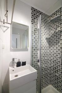 a bathroom with a white sink and a shower at Gabriel Apartments - JAFFA Street 214 Suits + Balcony in Bet HaKerem