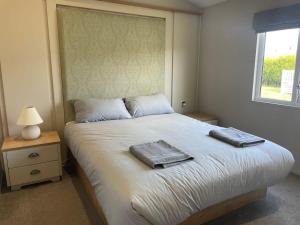 a bedroom with a bed with two towels on it at 42 Woodland Walk Pevensey Bay Holiday Park sleeps 6 in Pevensey